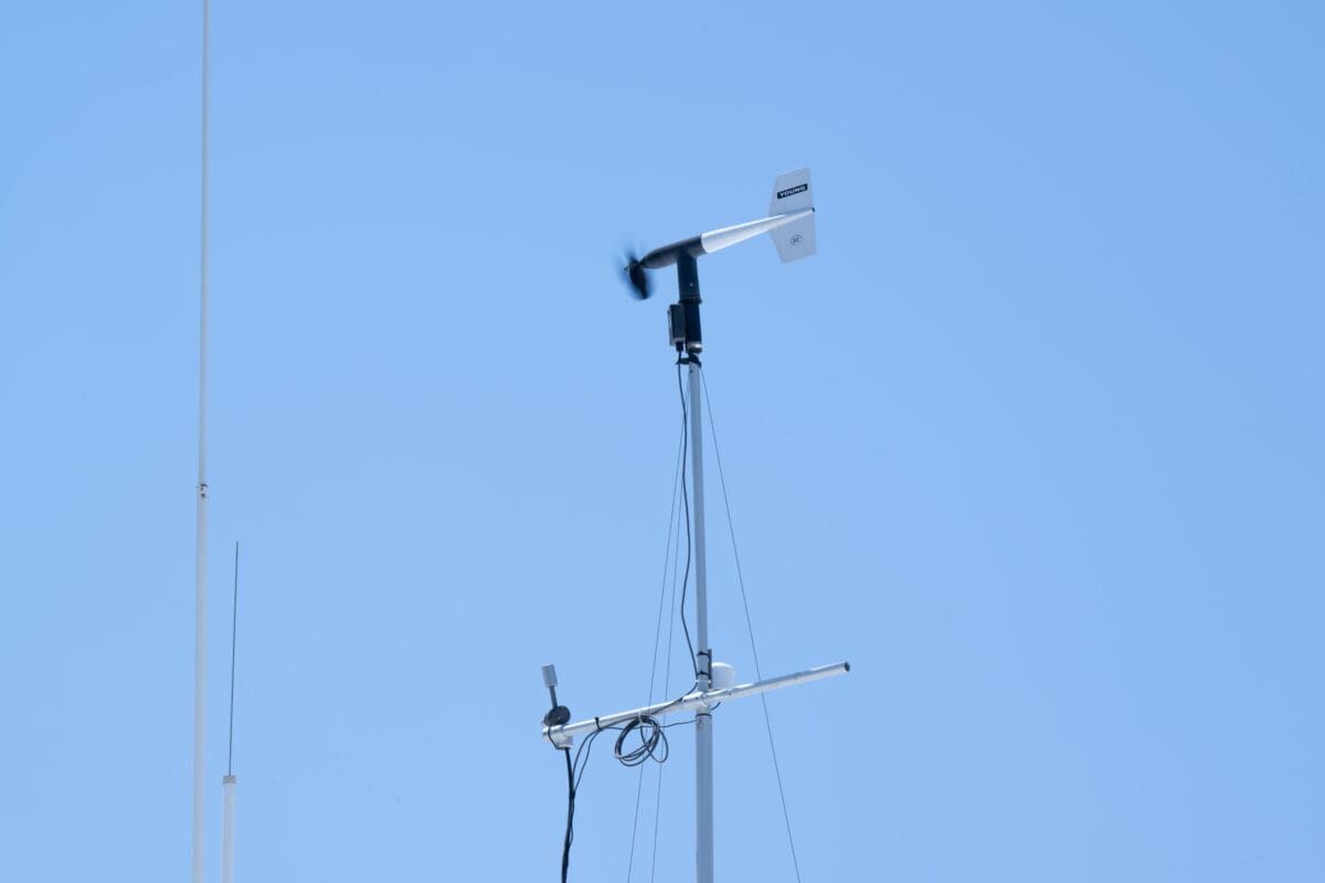 A tall pole with an anemometer and sensors attached stands proudly against a clear blue sky, reminiscent of the flagpoles that flutter at Port Hueneme Little League games.