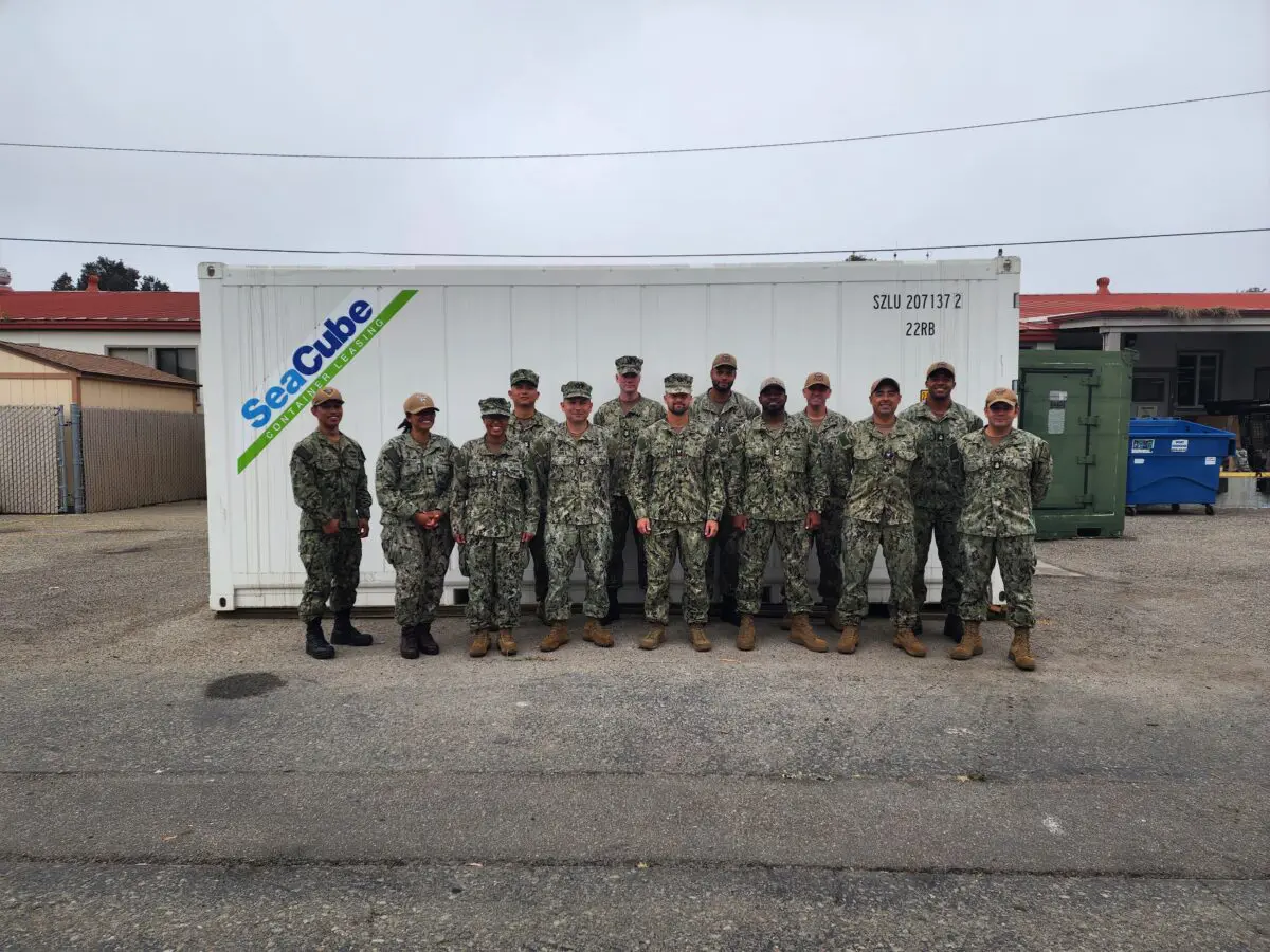 A group of uniformed military personnel stands in front of a white storage container labeled "SeaCube," showcasing the importance of the $3.935 million state grant for Port of Hueneme as Governor ramps up California's Port Data Partnership Program.