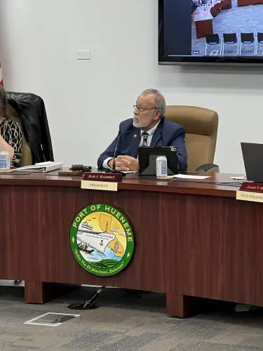 A man seated at a desk with a Port of Hueneme emblem, speaking into a microphone about the recent $3.935 million state grant as Governor ramps up the California Port Data Partnership Program.